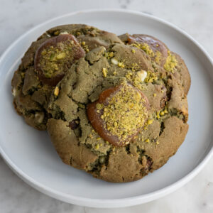 These pistachio white chocolate cookies are a JL Patisserie classic. The cookie dough is made with imported pistachio praline with chunks of caramelized pistachios and white chocolate chips. Once baked, the cookies are filled and topped with sea salted caramel. Crushed pistachios are sprinkled on top to finish.
